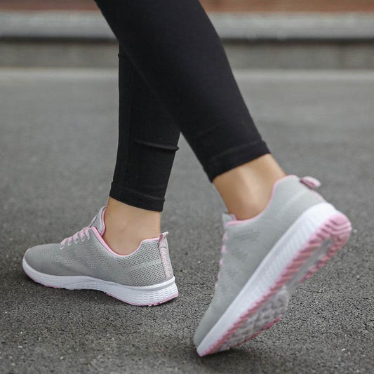 Holy Mango Store women's lightweight sports sneakers in gray and pink being worn with black leggings