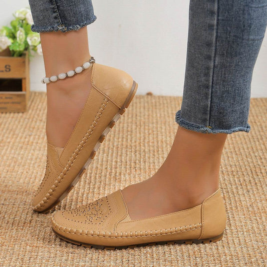 Beige casual slip-on shoes for women with stitched detailing worn with denim jeans