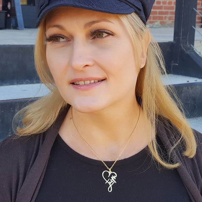 Woman wearing a stainless steel cross necklace with heart design from Holy Mango Store