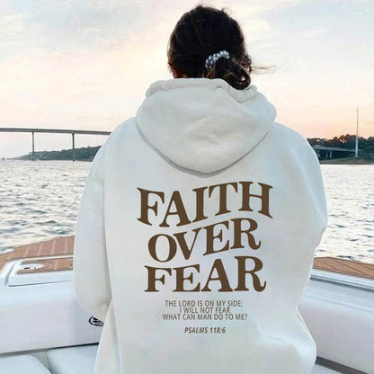 Person wearing white Faith Over Fear hoodie with scripture Psalms 118 6 on boat at sunset