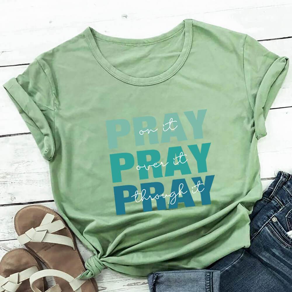 Green faith themed t shirt from Holy Mango Store with pray text design styled with jeans and sandals