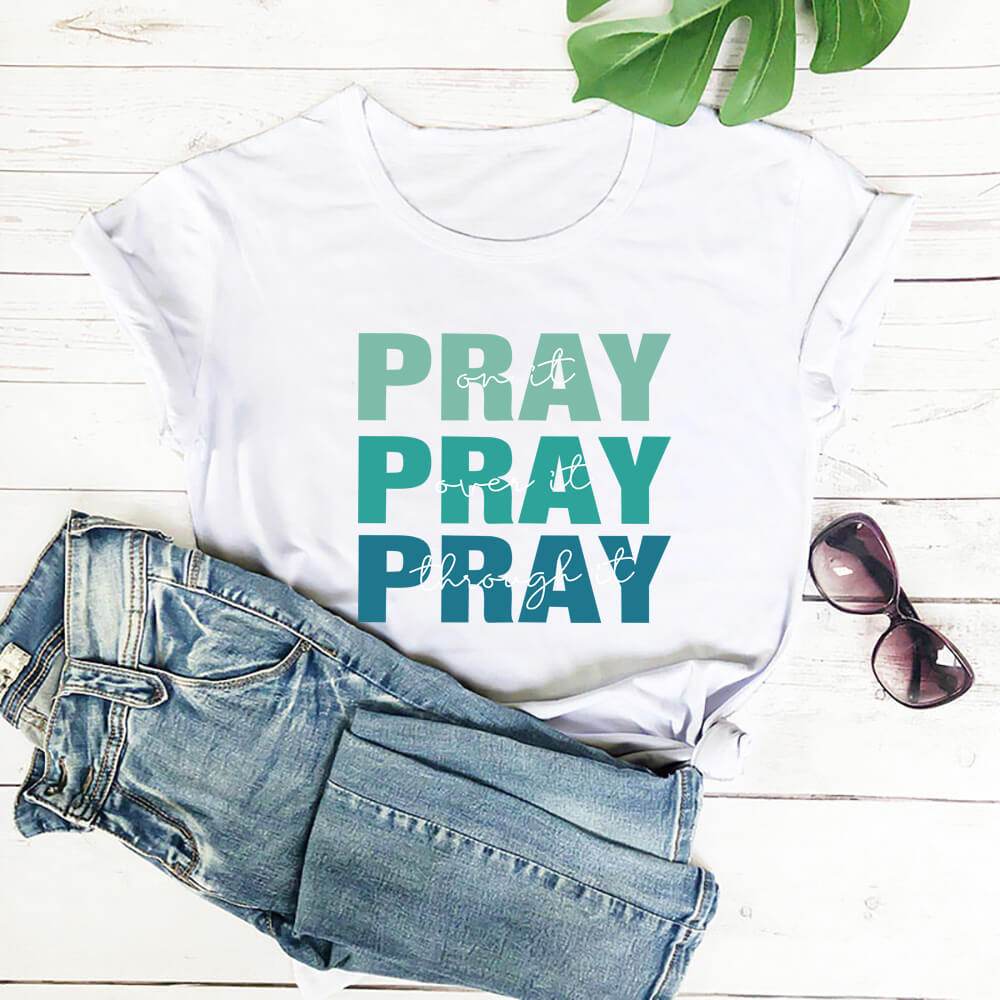 White faith themed t shirt with the word PRAY in blue and green shades from Holy Mango Store
