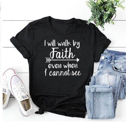 Black t-shirt with inspirational bible verse apparel reading I will walk by faith paired with jeans and white sneakers
