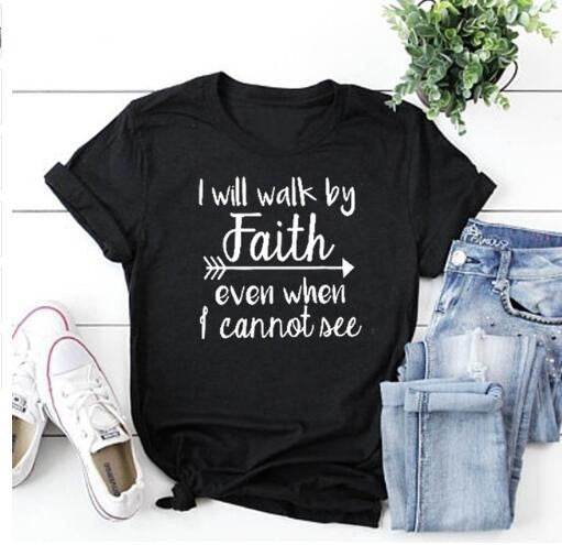 Black t-shirt with inspirational bible verse apparel reading I will walk by faith paired with jeans and white sneakers