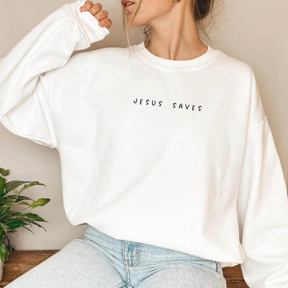 Woman wearing a white Jesus Saves sweatshirt with black text in a casual indoor setting