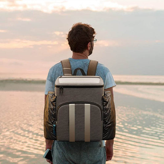 Holy Mango Store large insulated backpack cooler worn by man at beach with front pocket and dual side pockets