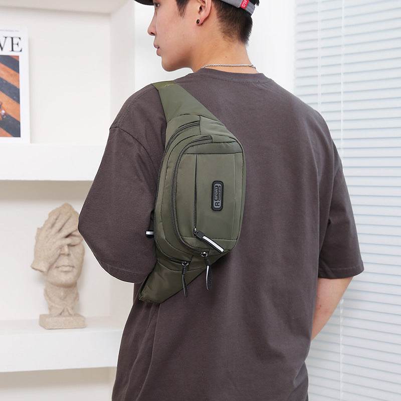 Mens crossbody bag with multiple pockets in olive green worn by a man in casual outfit