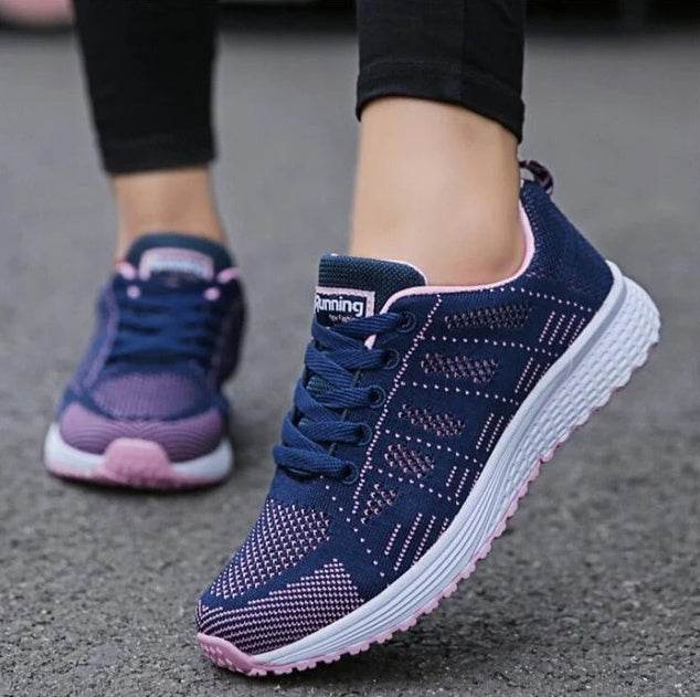 Women's lightweight sports sneakers in navy and pink from Holy Mango Store being worn outdoors