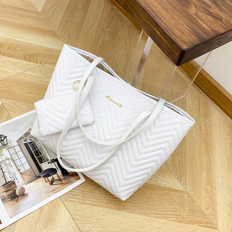 Large quilted shoulder bag with zipper in white from Holy Mango Store on wooden floor