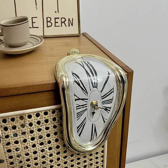 DALI inspired melting clock gold trim draped over mid century wooden cabinet edge with cup and framed print