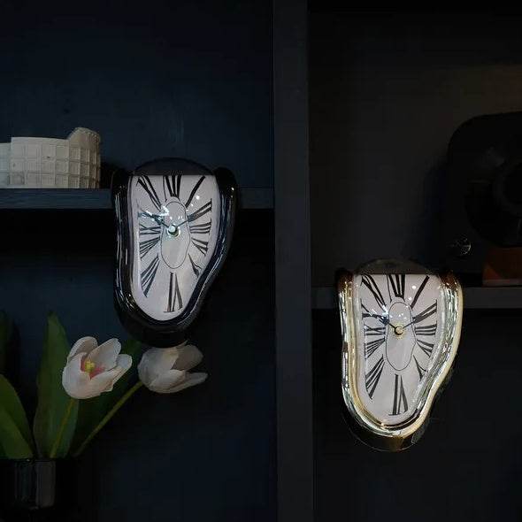 DALI inspired melting clock pair on dark shelf decorative surreal wall clocks with Roman numerals black and gold