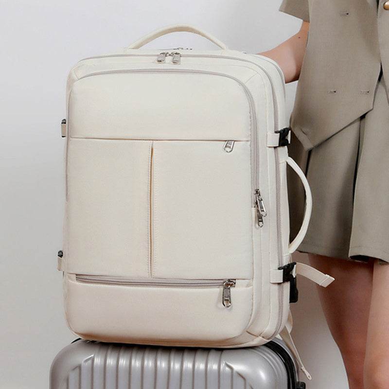 Holy Mango Store cream large capacity travel backpack with multiple zip pockets and top handle on suitcase